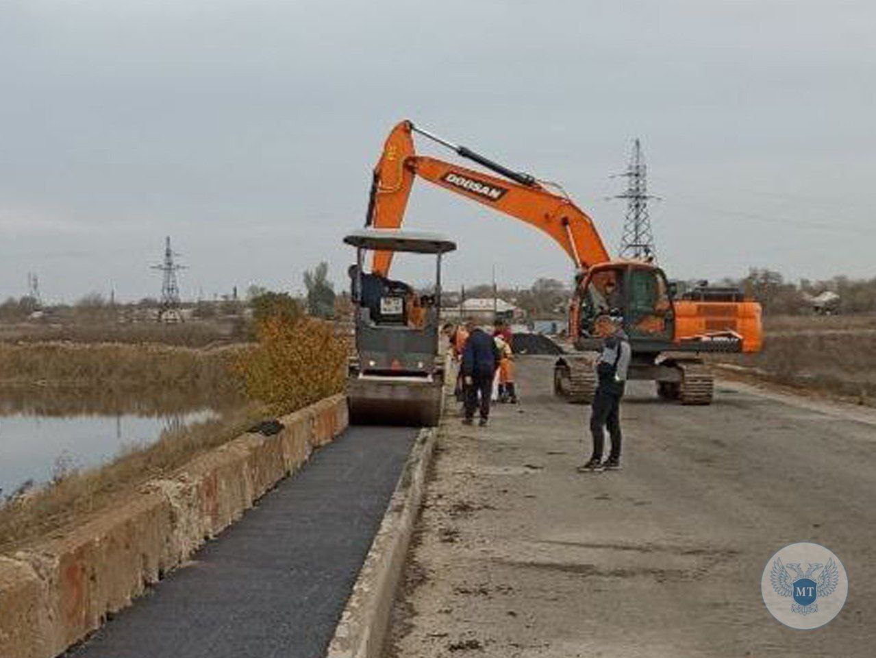 В селе Павлополь приступили к укладке асфальта на пешеходных зонах строящегося моста через р. Кальмиус